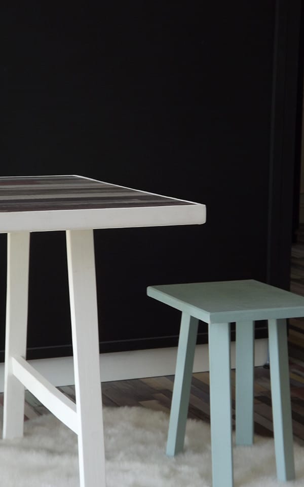 Table enfant avec 2 tabourets jaune et bleu. Cette table dispose d'un plan de travail en parquet stratifié.