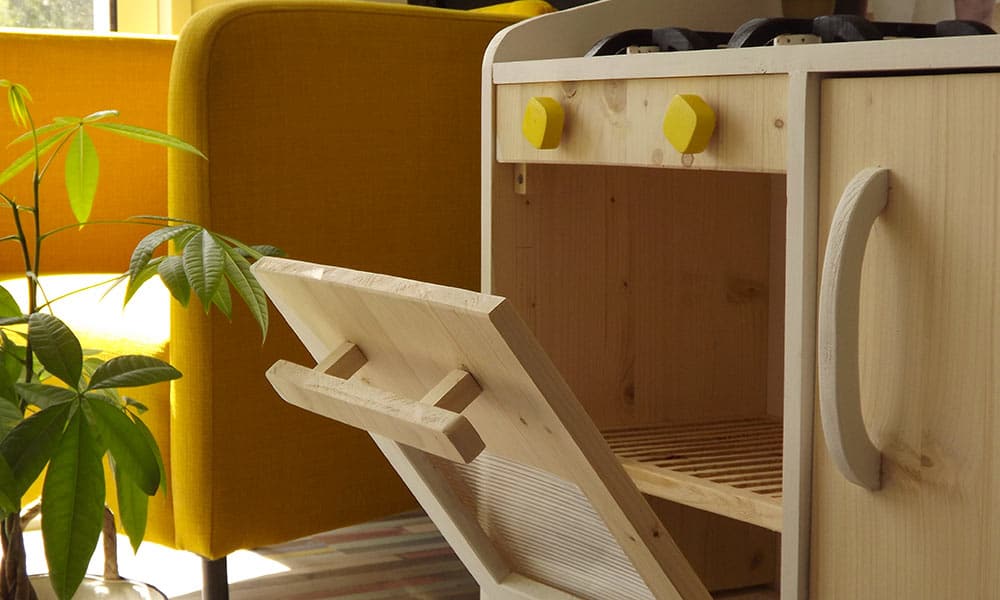 Cuisine en bois jouet enfant avec tous les équipements d'une cuisine moderne comme un four composé de sa grille.